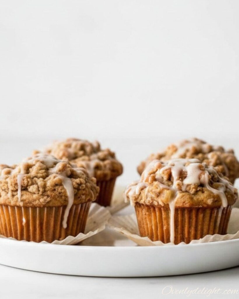 Bakery-style apple cinnamon crumb muffins on cooling rack