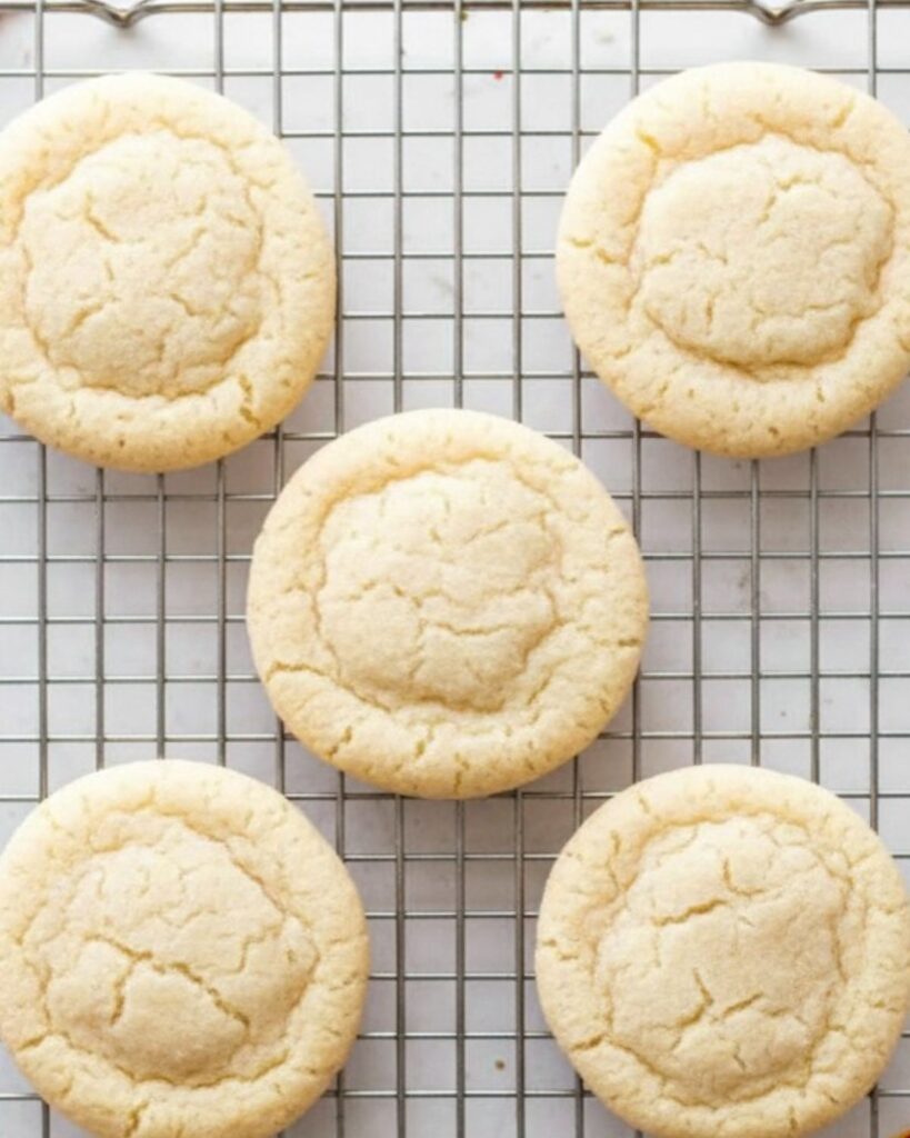 Freshly baked sugar cookies on a cooling rack, soft center and crisp edges