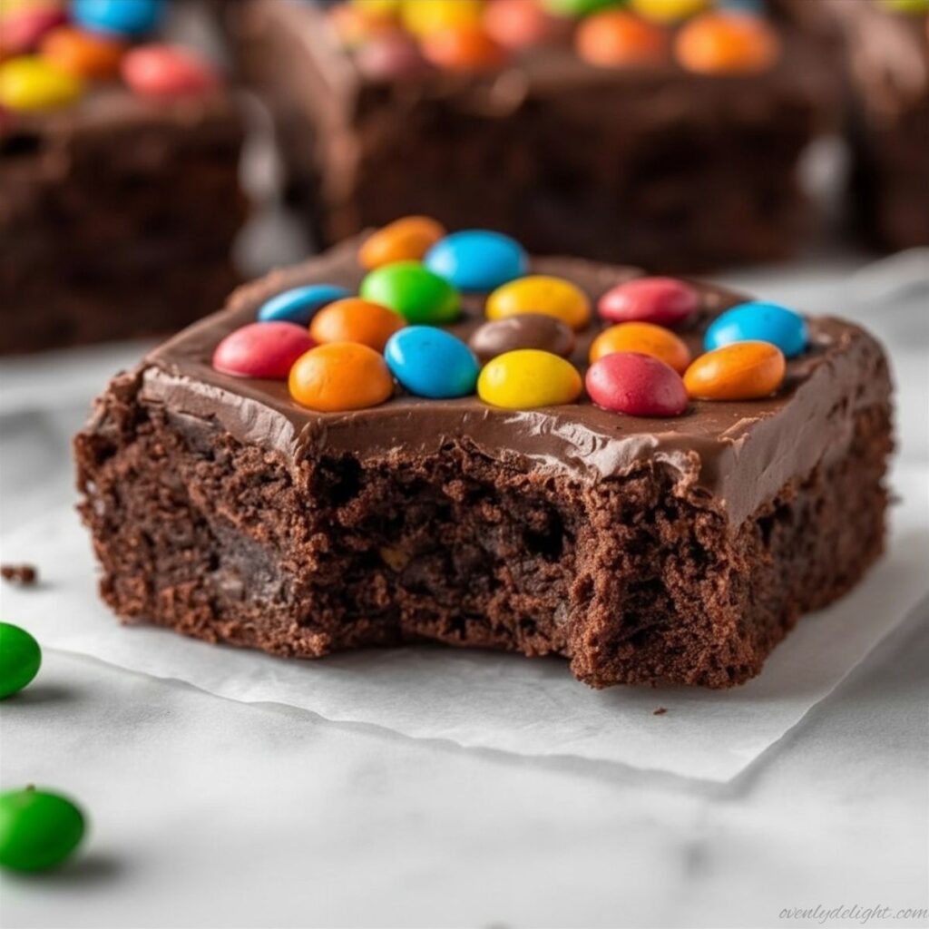 Slice of Cosmic Brownies with chewy center, shiny chocolate topping, and rainbow candy pieces