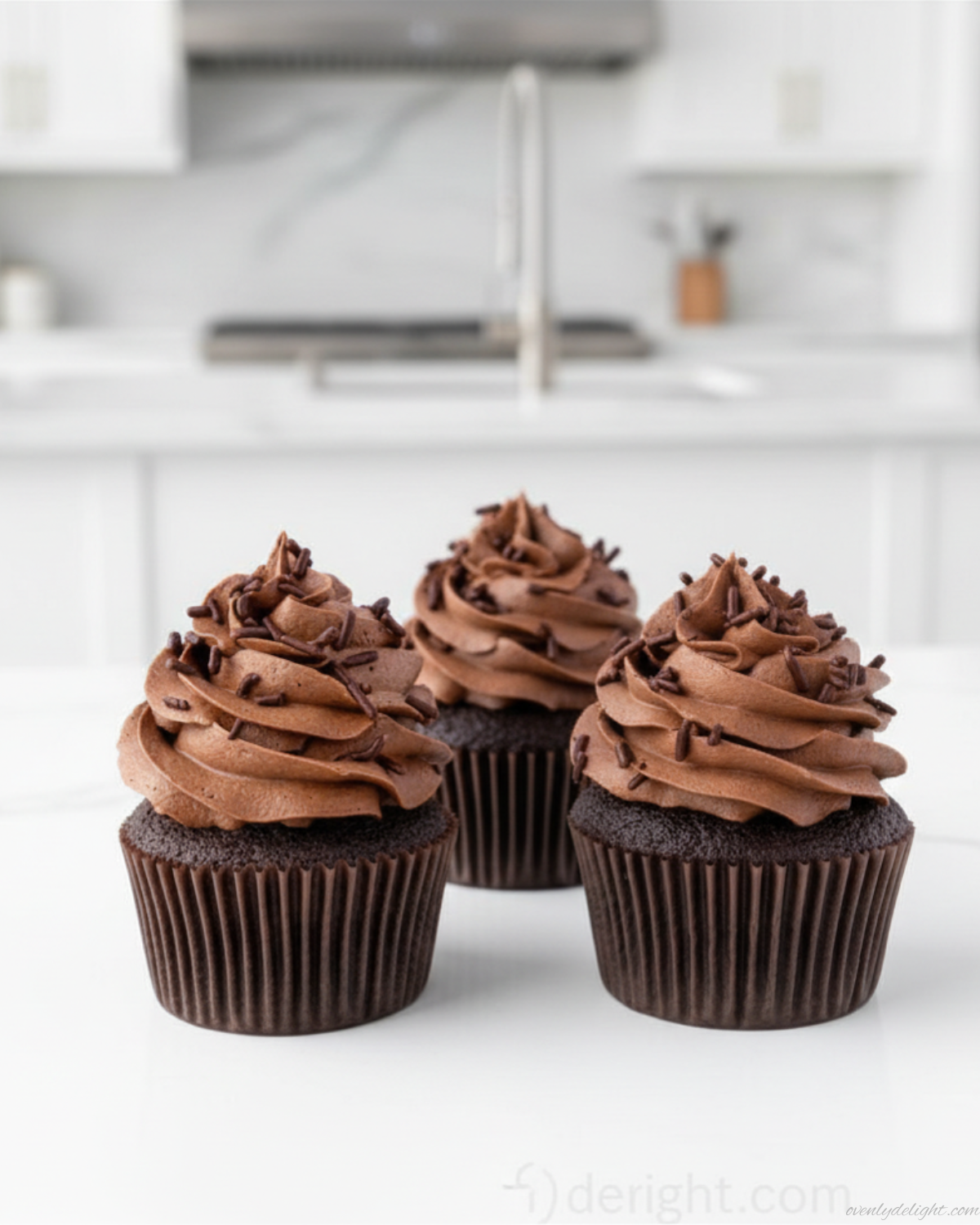 Homemade chocolate cupcakes topped with rich buttercream frosting and cocoa dust