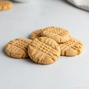 Peanut butter cookies stacked on a plate with crisscross fork marks