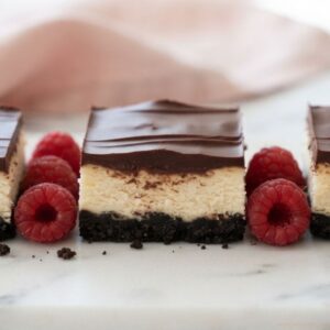 Creamy White Chocolate Cheesecake Bars topped with silky chocolate ganache
