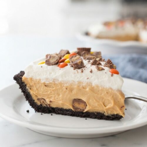 Creamy no-bake peanut butter pie with Oreo cookie crust, whipped topping, and peanut butter candies.