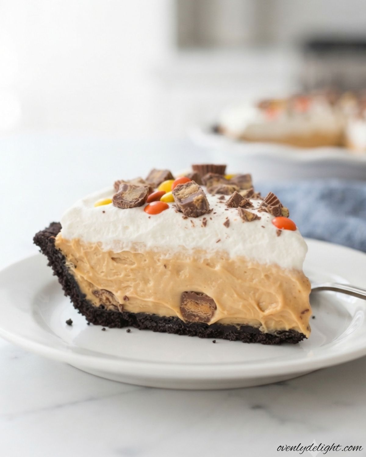Creamy no-bake peanut butter pie with Oreo cookie crust, whipped topping, and peanut butter candies.