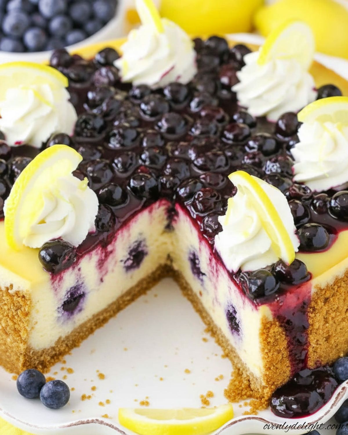 Easy Lemon Blueberry Cheesecake on a graham cracker crust with fresh blueberry sauce.