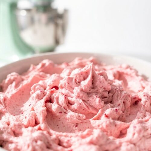 Fresh raspberry buttercream frosting with vibrant pink color and rich, creamy texture.