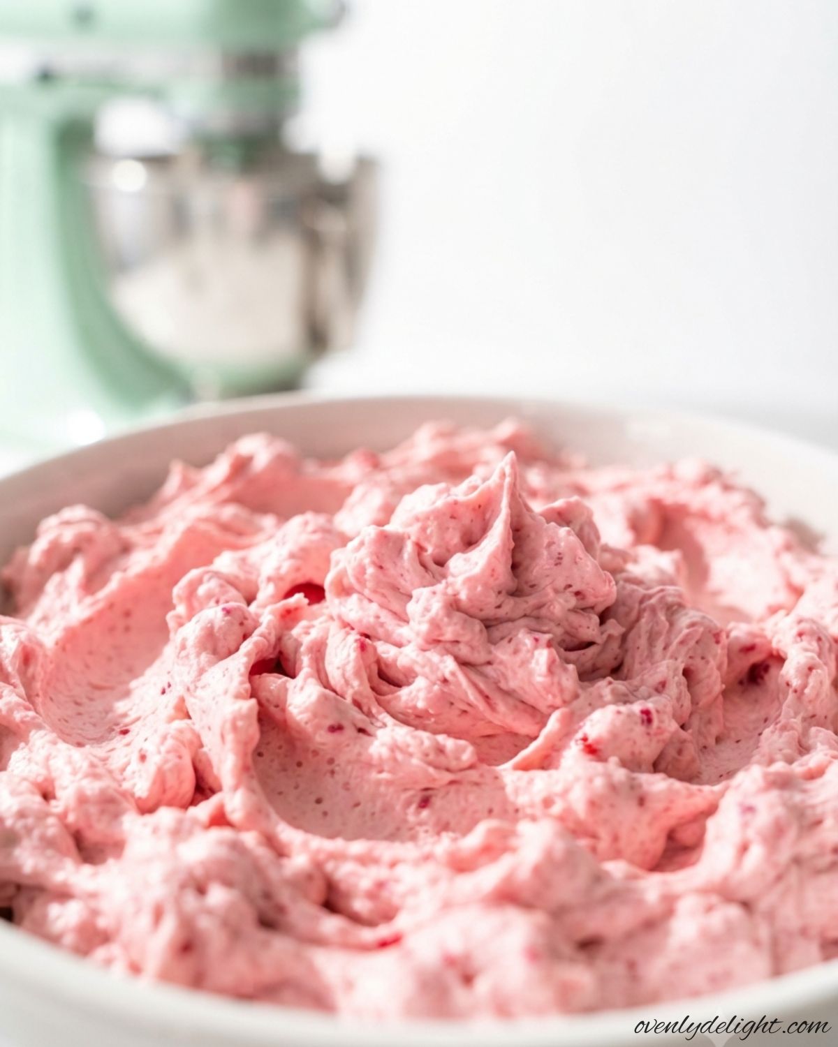 Fresh raspberry buttercream frosting with vibrant pink color and rich, creamy texture.