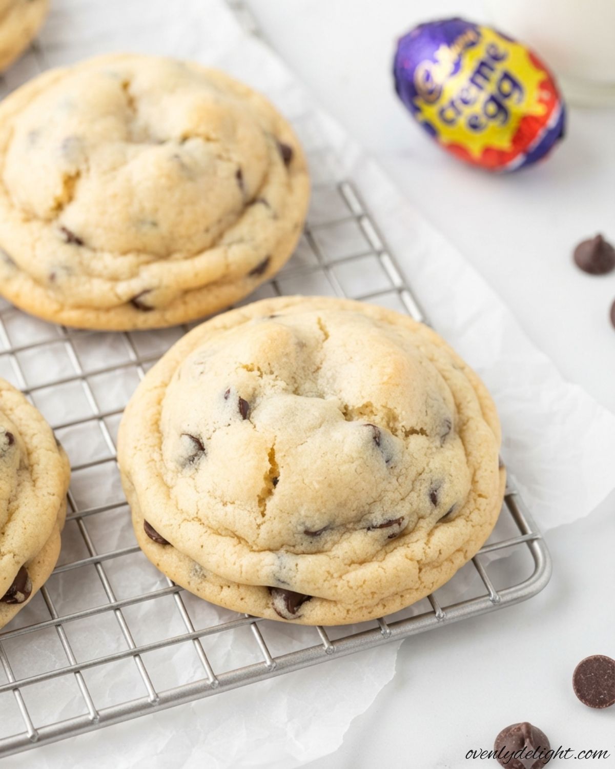 Homemade Cream Egg Stuffed Cookies with a melted chocolate and fondant center on a cooling rack.