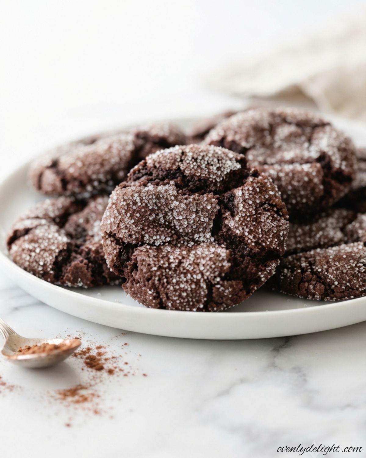 Soft and chewy chocolate sugar cookies topped with sugar crystals on a baking tray