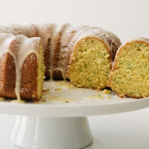 Fresh lemon zucchini loaf cake topped with a light lemon glaze, bakery-style presentation.